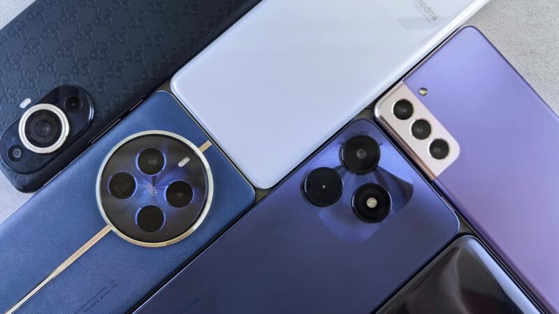 Top view of various modern smartphones showcasing diverse camera designs on flat surface.